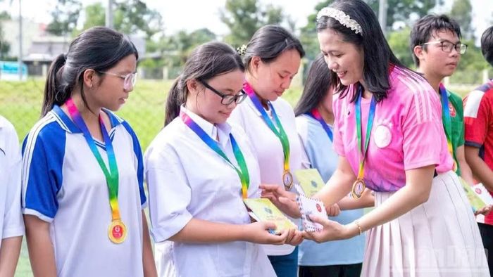 Cô Nguyễn Thị Minh Tâm, Chủ nhiệm câu lạc bộ thanh niên khuyết tật tỉnh Đồng Tháp trao quà cho học sinh có hoàn cảnh khó khăn. (Ảnh: LÝ OANH)