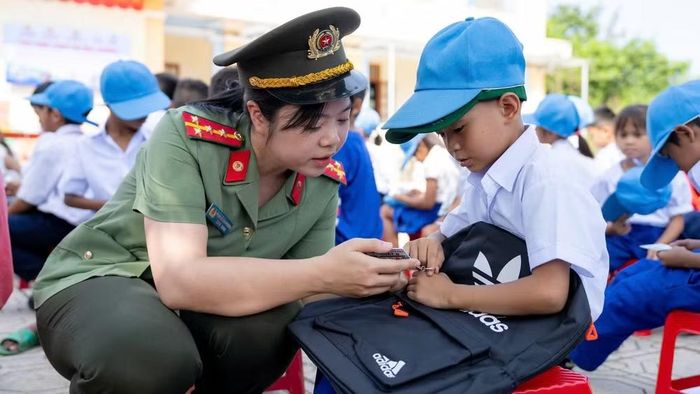 Tặng thẻ, hướng dẫn sử dụng “Thẻ kỹ năng an toàn” cho học sinh. (Ảnh: NHẬT QUANG)