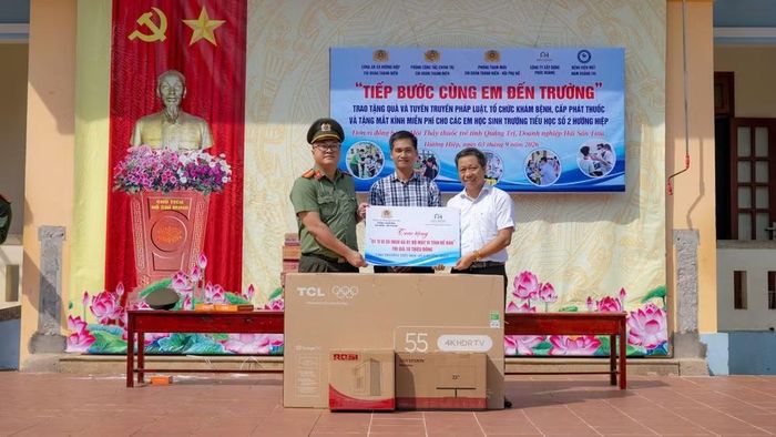 Đoàn công tác của các phòng chức năng Công an tỉnh Quảng Trị và nhà tài trợ trao tặng ti-vi, máy vi tính Trường tiểu học số 2 Hướng Hiệp. (Ảnh: NHẬT QUANG)