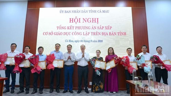 Lãnh đạo Tỉnh ủy và Ủy ban nhân dân tỉnh Cà Mau (đứng giữa) tặng hoa và Bằng khen cho các tập thể, cá nhân có thành tích xuất sắc trong sắp xếp trường, lớp. (Ảnh: HỮU TÙNG)