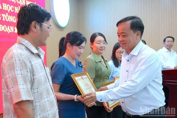 Phó Bí thư Thường trực Tỉnh ủy Cà Mau Huỳnh Quốc Việt (bìa phải) tặng Bằng khen của Chủ tịch tỉnh cho các tập thể, cá nhân có thành tích xuất sắc trong công tác hỗ trợ xây dựng nhà. (Ảnh: HỮU TÙNG)