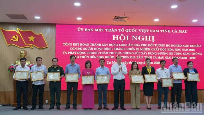 Bí thư Tỉnh ủy Cà Mau Nguyễn Hồ Hải (đứng giữa) tặng Bằng khen của Chủ tịch tỉnh cho các tập thể, cá nhân có thành tích xuất sắc trong công tác hỗ trợ xây dựng nhà. (Ảnh: HỮU TÙNG)