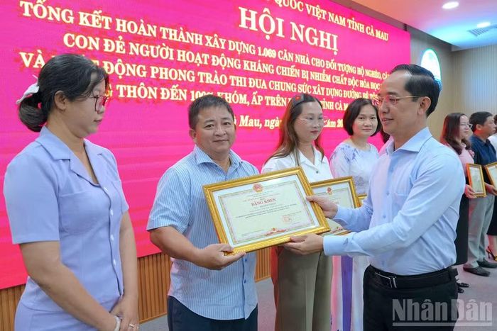 Phó Bí thư Tỉnh ủy, Chủ tịch Ủy ban Mặt trận Tổ quốc Việt Nam tỉnh Cà Mau Hồ Thanh Thủy tặng Bằng khen của Chủ tịch tỉnh cho các tập thể, cá nhân có thành tích xuất sắc trong công tác hỗ trợ xây dựng nhà. (Ảnh: HỮU TÙNG)