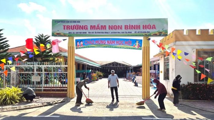 Tập thể cán bộ, giáo viên Trường mầm non Bình Hòa làm vệ sinh trước giờ khai giảng năm học mới.