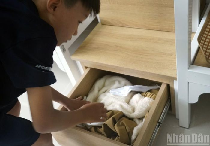 Một học sinh đang mở tủ đựng đồ cá nhân ở giường ký túc xá trong nhà trường. (Ảnh: LÊ ĐÌNH THÌN)