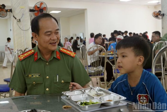 Đại tá Nguyễn Nguyện Luân, Hiệu trưởng Trường Văn hóa công an nhân dân V, Công an Thành phố Hồ Chí Minh trò chuyện với em học sinh trong bữa trưa ngày 4/9. (Ảnh: LÊ ĐÌNH THÌN)