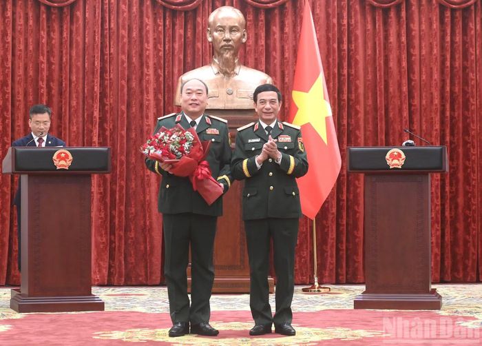 Đại tướng Phan Văn Giang, Ủy viên Bộ Chính trị, Phó Bí thư Quân ủy Trung ương, Phó Thủ tướng, Bộ trưởng Quốc phòng tặng hoa chúc mừng Thượng tướng Lê Quang Đạo.