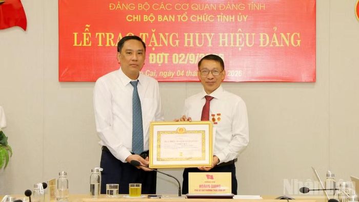 Phó Bí thư Thường trực Tỉnh ủy, Chủ tịch Hội đồng nhân dân tỉnh Lào Cai Hoàng Giang trao Huy hiệu 35 năm tuổi Đảng cho đồng chí Ngô Hữu Quý. (Ảnh: TÂM THỜI)