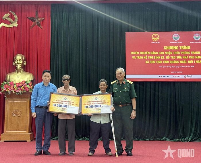 Ông Nguyễn Huynh (thứ hai từ bên trái) nhận hỗ trợ 30 triệu đồng để sửa chữa nhà cửa. Ảnh: NGỌC MINH