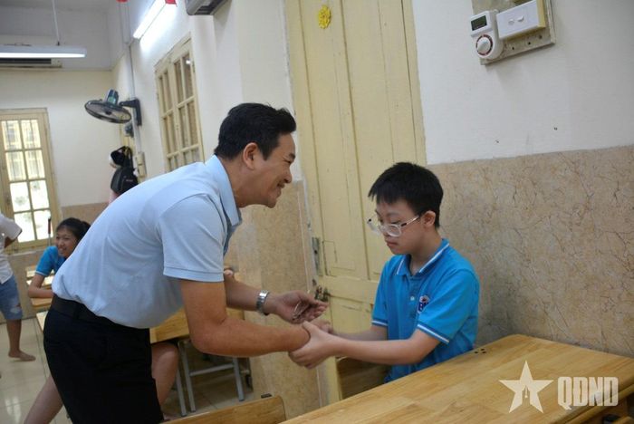  Thầy hiệu trưởng hướng dẫn học sinh bắt tay với khách.