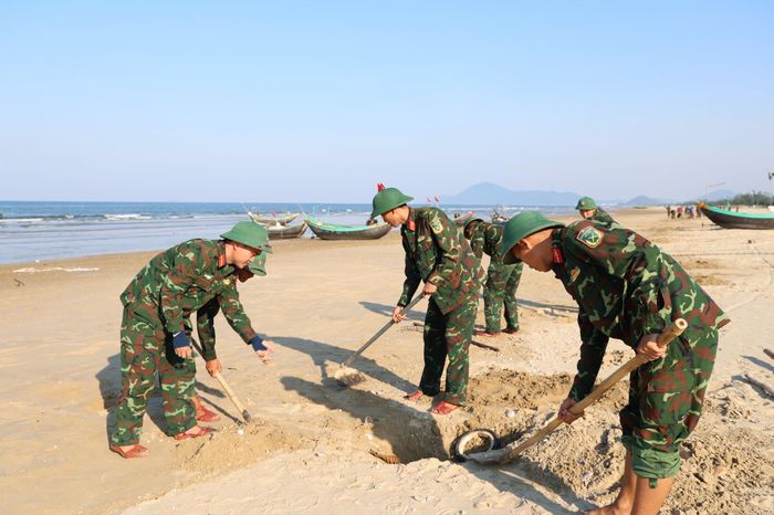  Cán bộ, chiến sĩ Trung đoàn 841 thu gom, chôn lấp vỏ nghêu tím dạt vào bờ biển 