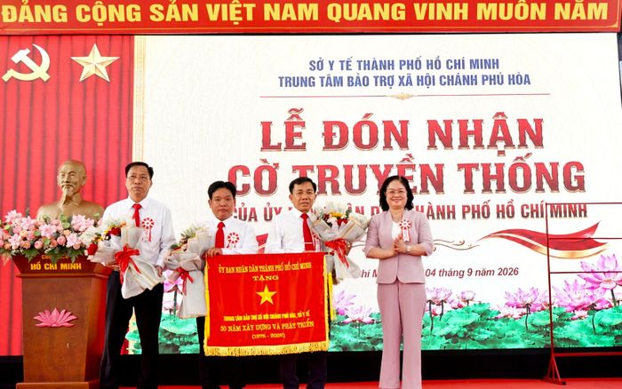  ﻿Đồng chí Nguyễn Thị Mỹ Hằng - Ủy viên Ban Thường vụ Thành ủy TPHCM, Bí thư Đảng ủy, Chủ tịch HĐND phường Bến Cát thay mặt lãnh đạo thành phố trao Cờ truyền thống của UBND TPHCM tặng. Ảnh: DUY TRẦN﻿ 