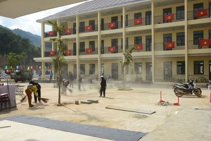Giáo viên, nhân viên Trường Phổ thông nội trú Tiểu học & THCS Tây Giang vệ sinh sân trường.
