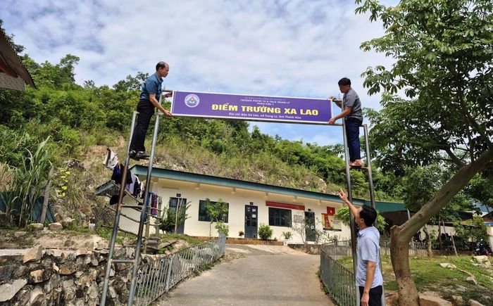 Các thầy giáo chỉnh trang biển tên điểm trường.