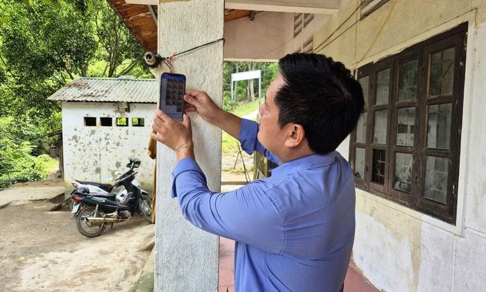 Ở điểm trường Suối Tung, hiện nay sóng điện thoại đang rất chập chờn nên ông Ngân Văn Lon - Phó Chủ tịch UBND xã Trung Lý phải treo chiếc điện thoại của mình lên cột để đón sóng.