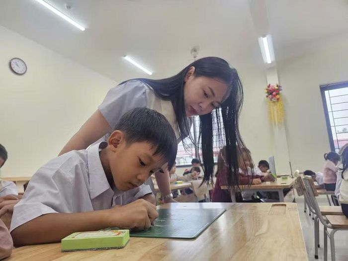 Cô Hoàng Thị Hằng hướng dẫn học sinh viết chữ.