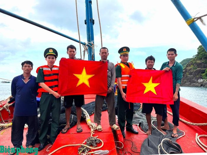 Cùng với tuyên truyền pháp luật, Đồn Biên phòng Hòn Chuối đã trao tặng cờ Tổ quốc cho ngư dân. Ảnh: Hoàng Tá