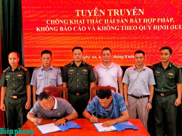 Các chủ tàu, thuyền trưởng ký cam kết chấp hành các nội dung quy định khi ra biển khai thác thủy sản tại buổi Tuyên truyền chống khai thác IUU do Đồn Biên phòng cửa khẩu cảng Cửa Lò - Bến Thủy phối hợp tổ chức. Ảnh: Lê Thạch
