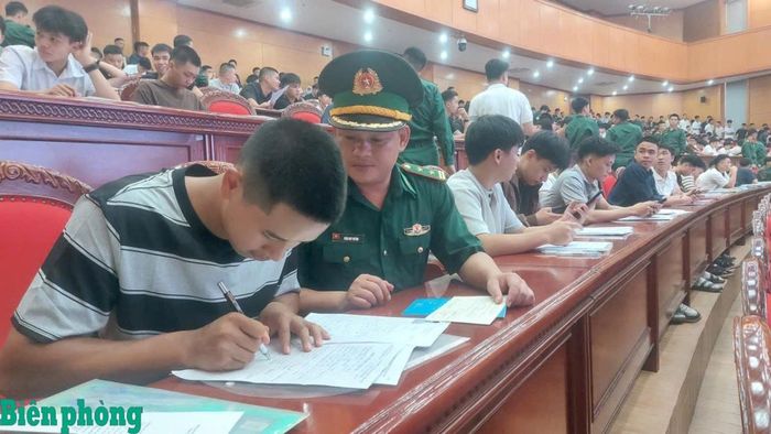 Cán bộ Biên phòng hỗ trợ em Phàn Tiến Dũng làm thủ tục nhập học. Ảnh: Trần Huỳnh