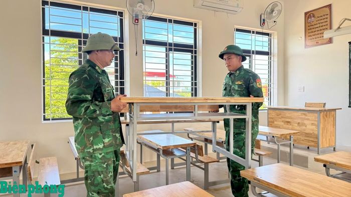 Cán bộ, chiến sỹ Bộ đội Biên phòng tỉnh Hà Tĩnh giúp Trường Phổ thông nội trú Tiểu học và Trung học cơ sở Sơn Kim 1 sắp xếp bàn ghế. Ảnh: Thế Mạnh