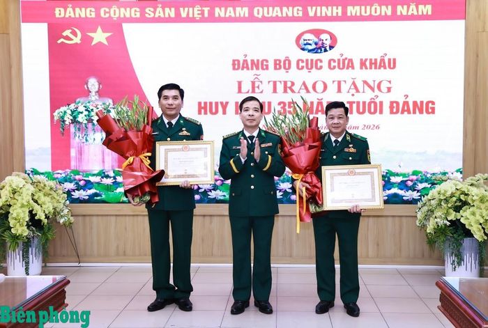 Thừa ủy quyền của Ban Thường vụ Quân ủy Trung ương, Đại tá Phùng Đức Hưng, Bí thư Đảng ủy, Phó Cục trưởng Cục Cửa khẩu Bộ đội Biên phòng trao tặng Huy hiệu 35 năm tuổi Đảng, tặng hoa chúc mừng Thiếu tướng Đỗ Ngọc Toàn và Đại tá Trần Quốc Khánh. Ảnh: Dân Chủ