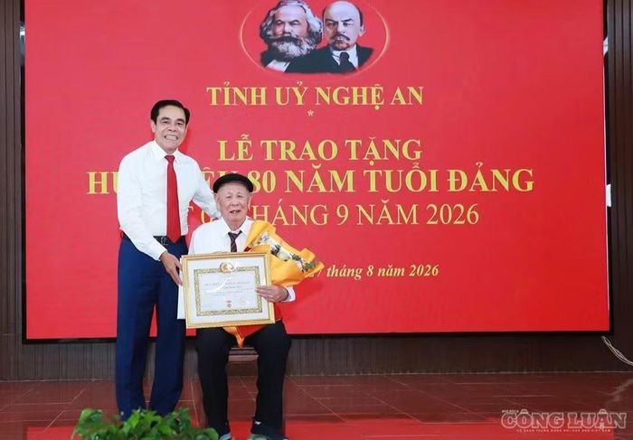 Ông Võ Trọng Hải - Phó Bí thư Tỉnh ủy, Chủ tịch UBND tỉnh Nghệ An - trao quyết định, giấy chứng nhận, tặng hoa chúc mừng cụ Hoàng Ngọc Túy. (Ảnh: Thành Duy)