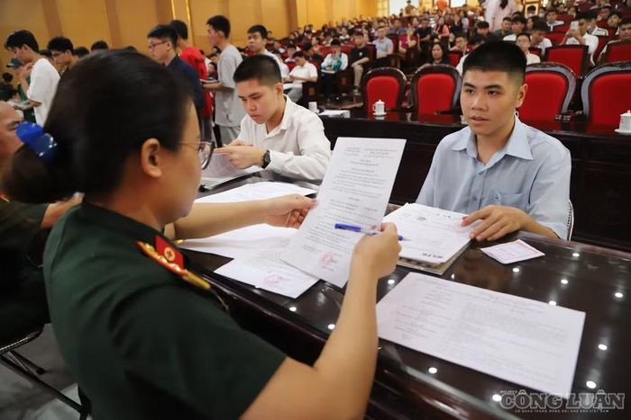 Các tân học viên được cán bộ Học viện Quân y hướng dẫn hoàn thiện hồ sơ nhập học.