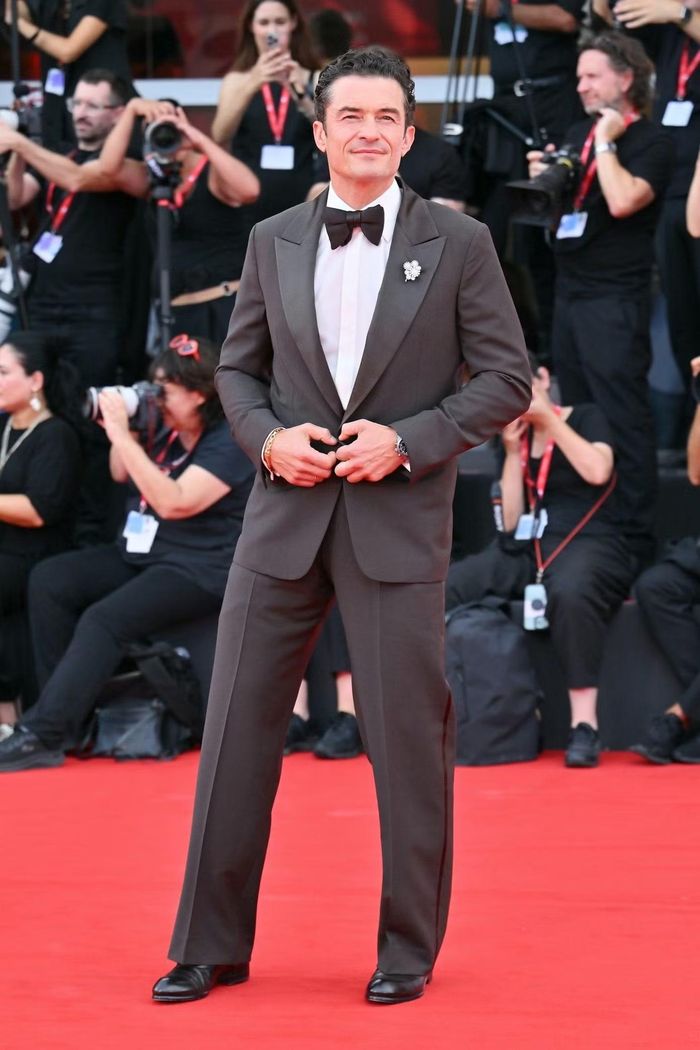 Orlando Bloom xuất hiện tại buổi công chiếu Bucking Fastard - tác phẩm tranh giải Sư tử vàng của đạo diễn Werner Herzog. Nam diễn viên mặc tuxedo Zegna, phối nơ đen và cài áo hình hoa bằng kim cương. Anh đóng cùng Kate Mara, Rooney Mara và Domhnall Gleeson trong phim.