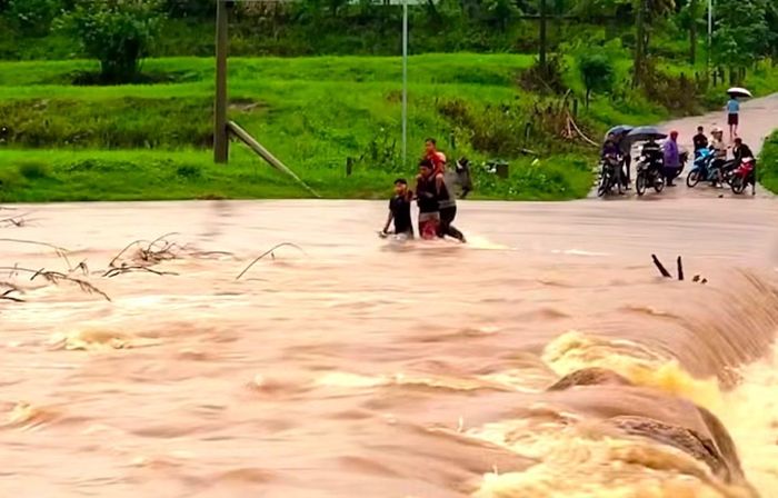 Một gia đình cố gắng vượt qua khu vực cầu tràn ở xã Ia Pa.