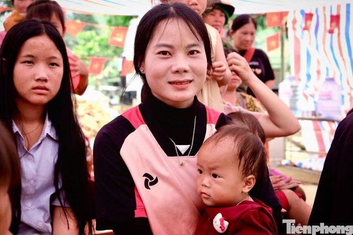  Chị Lý Thị Váng cùng đứa con út dự lễ khai giảng. 