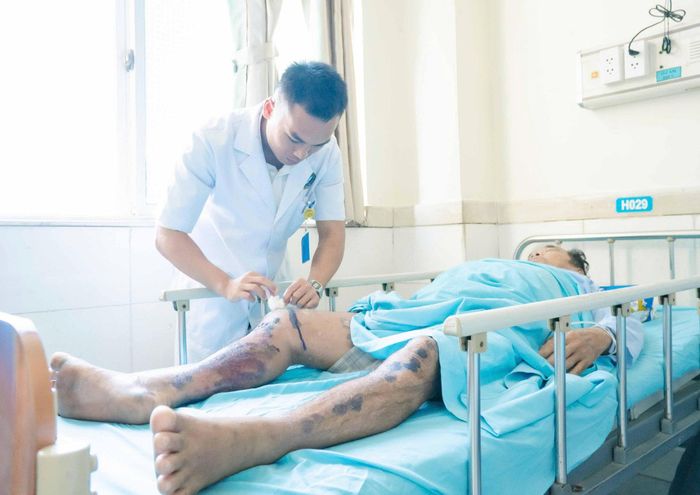 Ông Huỳnh Ngọc Châu được bác sĩ thăm khám các vết thương ở chân.