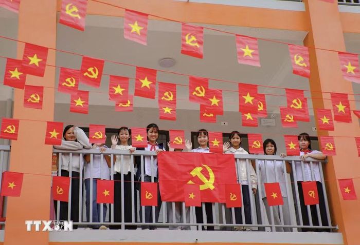 Học sinh Trường Phổ thông nội trú Tiểu học và Trung học cơ sở Sam Mứn tươi vui bên những lá cờ Đảng, cờ Tổ quốc được trang trí trên hành lang. (Ảnh: Xuân Tư/TTXVN)