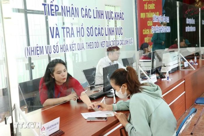 Hướng dẫn người dân làm thủ tục kinh doanh. (Ảnh: Dương Chí Tưởng/TTXVN)