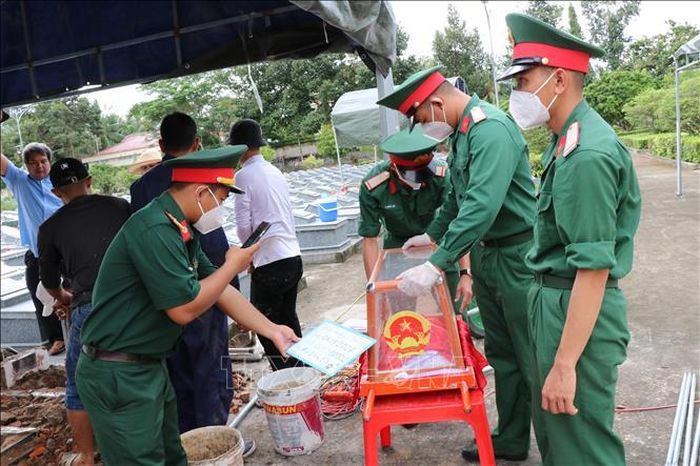 Các chiến sĩ lấy mẫu tại Nghĩa trang Liệt sĩ Tiểu Cần theo đúng quy trình kỹ thuật, phục vụ giám định ADN. Ảnh: Thanh Hòa/TTXVN