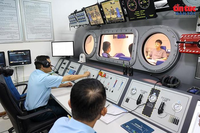 Cán bộ giám sát các chỉ số và hoạt động của ứng viên trong buồng giảm áp từ phòng điều khiển.
