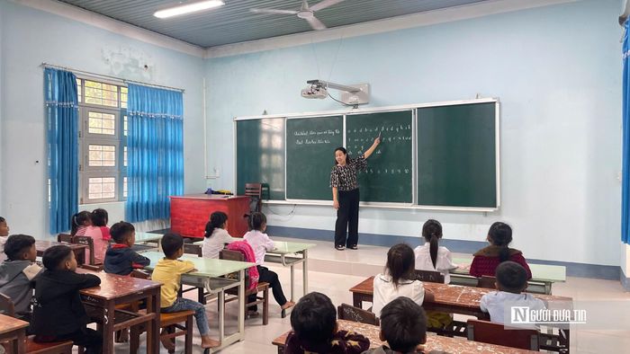 Cô giáo Nguyễn Thị Lan, giáo viên chủ nhiệm lớp 1 A (Trường Phổ thông nội trú tiểu học và THCS Ia Mơ (xã Ia Mơ) giúp các học sinh lớp 1 làm quen với chương trình. Ảnh: Ngọc Dung