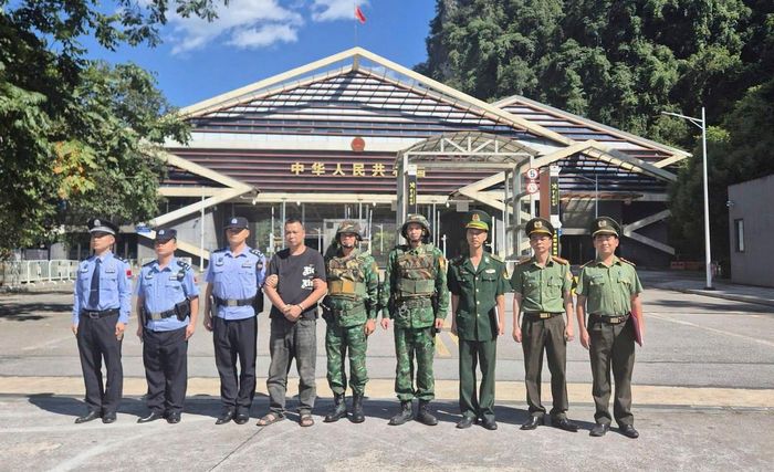 Lực lượng chức năng Cao Bằng (Việt Nam) tiến hành bàn giao, trao trả đối tượng phạm tội (áo đen) cho đơn vị chức năng Quảng Tây (Trung Quốc). Ảnh: Công an Cao Bằng