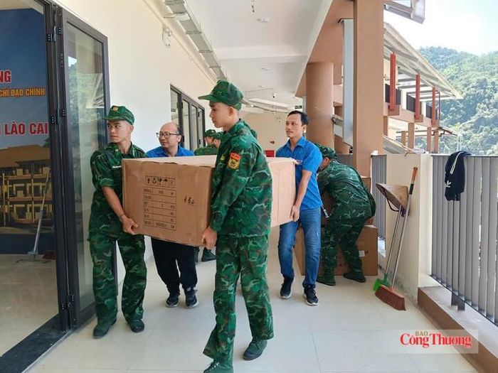 Lực lượng Bộ đội Đồn Biên phòng Mường Khương và các tình nguyện viên hỗ trợ vận chuyển đồ đạc vào trong lớp học.