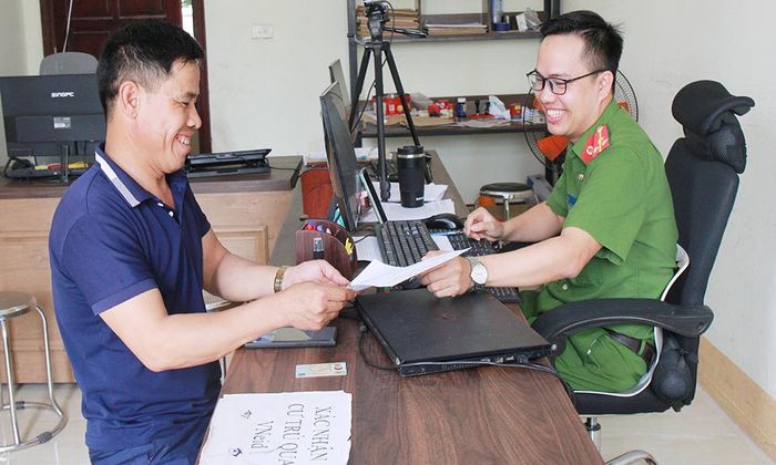 Cán bộ Công an xã Cẩm Lý hỗ trợ người dân nộp hồ sơ giải quyết thủ tục hành chính.