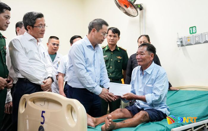 Chủ tịch UBND thành phố Nguyễn Mạnh Hùng tặng quà động viên ngư dân Nguyễn Văn Hội đang cấp cứu tại Bệnh viện Việt - Hàn Đà Nẵng (xã Núi Thành). Ảnh: HỒ QUÂN