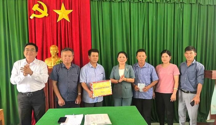  Đồng chí Nguyễn Thị Phong Vũ (đứng giữa) trao tặng phần quà cho Chi bộ thôn Hòa Hiệp. Ảnh: Nam Phú 