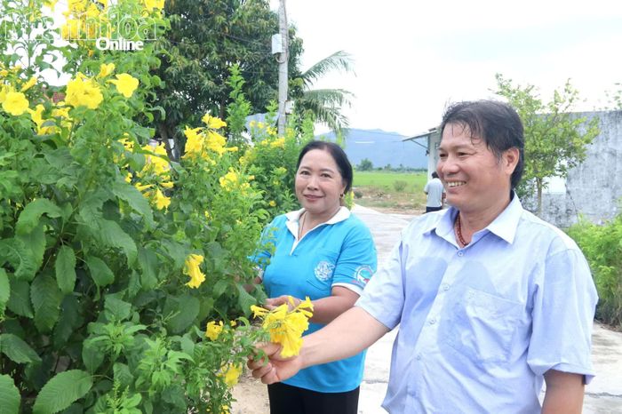Ông Nguyễn Quang Minh cùng đại diện Chi hội Phụ nữ thôn Lạc Lợi trao đổi về việc duy trì cây xanh, hoa trên tuyến đường xanh - sạch - đẹp.