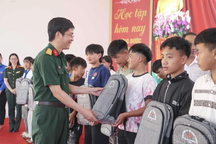 Thiếu tá Trần Văn Hiếu - Giám đốc Chi nhánh Trường Sơn 97 (Binh đoàn 12) trao tặng cặp sách cho học sinh Trường Phổ thông nội trú tiểu học và trung học cơ sở Y Tý.