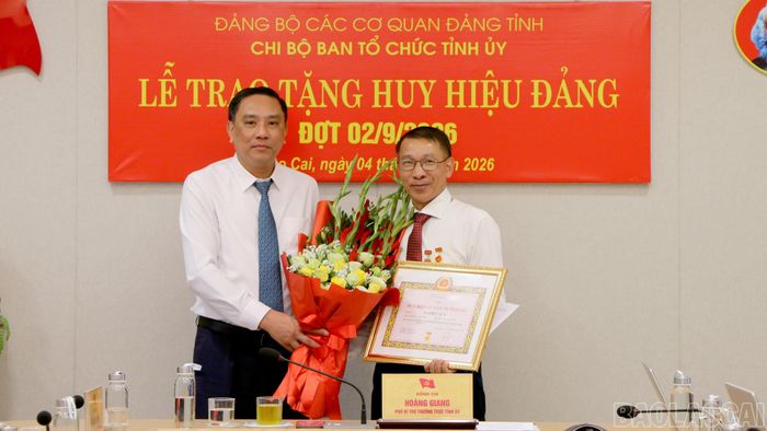 Phó Bí thư Thường trực Tỉnh ủy, Chủ tịch HĐND tỉnh Hoàng Giang trao Huy hiệu 35 năm tuổi Đảng và tặng hoa chúc mừng đồng chí Ngô Hữu Quý - Phó Trưởng ban Tổ chức Tỉnh ủy.
