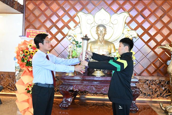 Tỉnh ủy viên, Phó Chủ tịch UBND tỉnh Đinh Văn Tuấn trao ngọn đuốc cho vận động viên tiêu biểu Lê Thị Mỹ Hiền