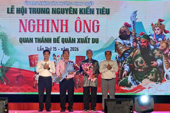 Tỉnh ủy viên, Phó Chủ tịch UBND tỉnh Đinh Văn Tuấn và lãnh đạo phường Phan Thiết tặng hoa đại diện Ban quản lý Quan Đế Miếu và Ban Tổ chức lễ hội