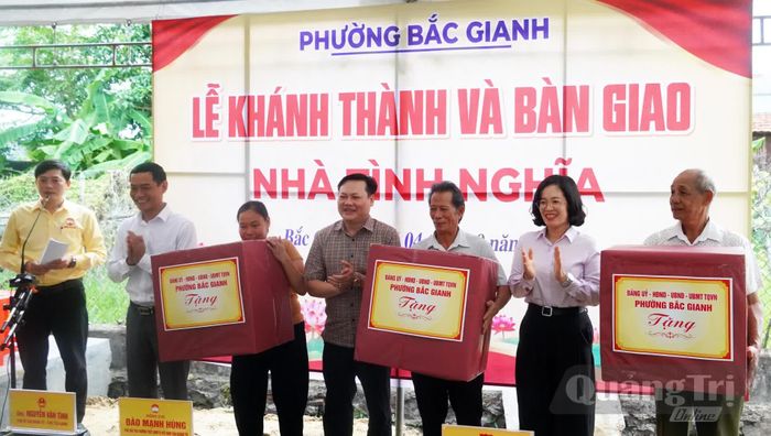 Đại diện lãnh đạo phường Bắc Gianh tặng quà cho các hộ gia đình - Ảnh: N.M
