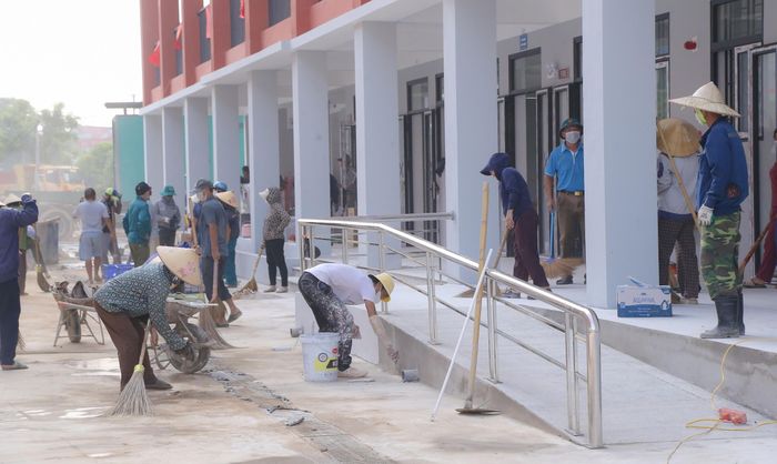 Để đẩy nhanh tiến độ, ngoài công nhân, chiến sĩ bộ đội, hàng trăm người dân xã Anh Sơn cũng đã có mặt để hỗ trợ nhà thầu các phần việc phụ trợ như dọn vệ sinh, lắp ghép, sắp xếp bàn ghế.