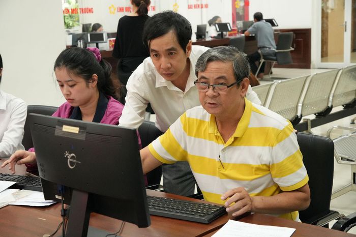 Cán bộ cơ sở hướng dẫn, hỗ trợ người dân làm các thủ tục hành chính online. Ảnh: Thạc Hiếu