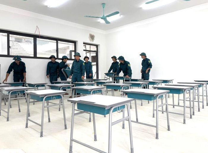 Lực lượng dân quân xã Trà Lĩnh hỗ trợ vận chuyển, sắp xếp bàn ghế tại các phòng học, chuẩn bị đón học sinh bước vào năm học mới.